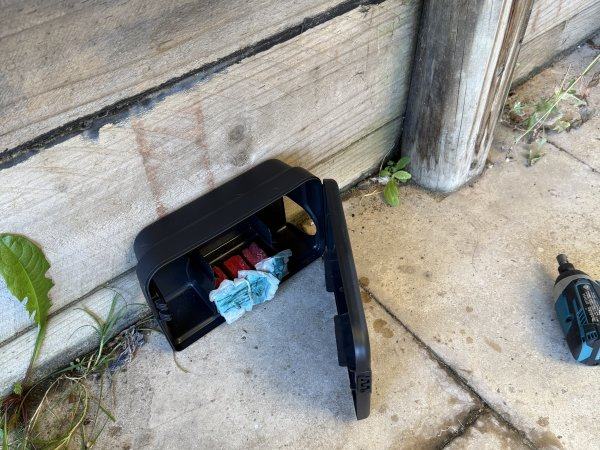 Rodent bait station opened to show the secured bait block inside